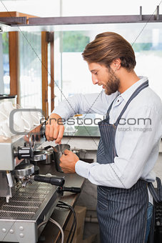 Handsome barista making a cup of coffee