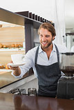 Handsome barista offering a cup of coffee
