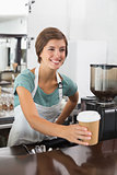Pretty barista holding disposable cup