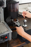 Barista grinding fresh coffee beans