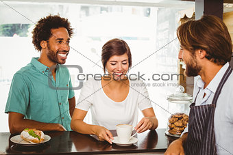 Barista talking with two customers
