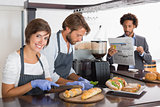 Happy servers preparing sandwiches together