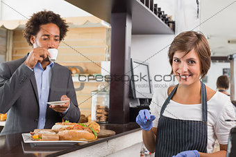 Happy server preparing food at counter