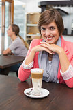 Pretty brunette enjoying her latte