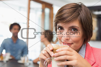 Pretty brunette enjoying her latte