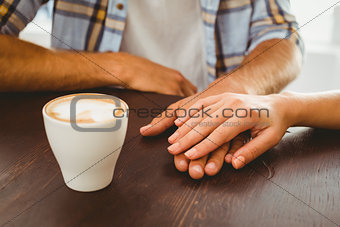Couple enjoying a coffee holding hands
