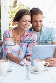 Happy couple on a date using tablet pc