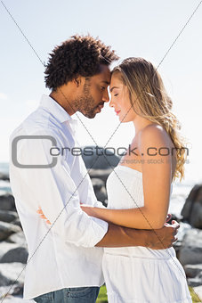 Gorgeous couple embracing by the coast