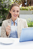 Beautiful businesswoman having a coffee using tablet