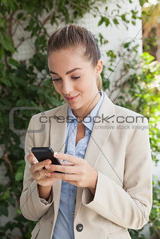 Beautiful businesswoman texting on phone
