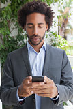 Handsome businessman texting on phone