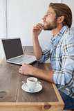 Casual man using laptop having coffee