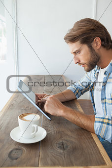 Casual man having a coffee using tablet