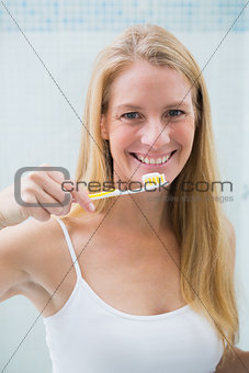 Happy woman brushing her teeth