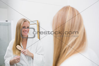 Happy blonde brushing her hair