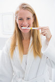 Happy blonde brushing her teeth