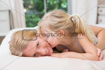 Cute little girl and mother on bed
