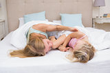 Cute little girl and mother on bed