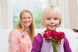 Happy woman holding red roses with daughter