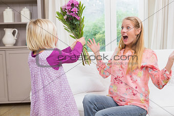 Little girl surprising her mother with flowers