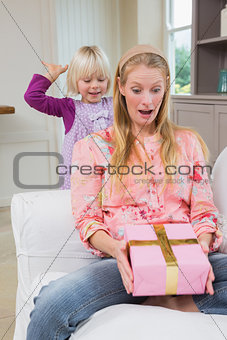 Little girl surprising her mother with gift