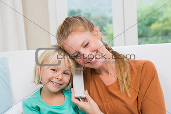 Happy mother and daughter on the couch on the phone