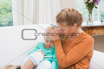 Mother taking the temperature of sick daughter