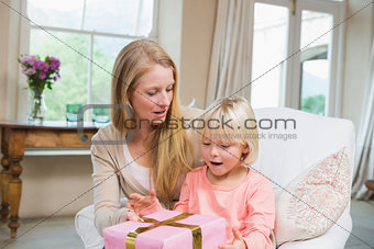 Daughter opening a present from mum
