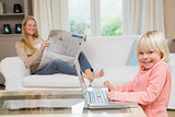 Cute daughter using laptop on coffee table