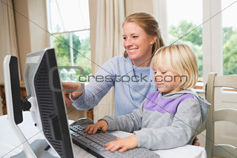 Cute daughter and mother using computer