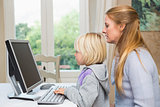Cute daughter and mother using computer