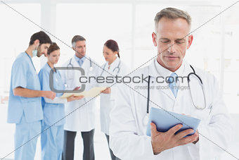 Serious doctor using his tablet