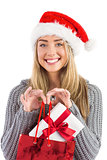 Festive blonde holding christmas gift and bag