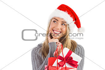 Festive blonde holding christmas gift and bag