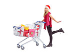 Festive blonde pushing trolley full of gifts