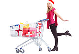 Festive blonde pushing trolley full of gifts