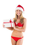 Festive fit blonde in red bikini showing gift