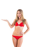 Fit blonde in red bikini presenting with hand