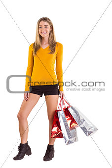 Stylish blonde smiling with shopping bags