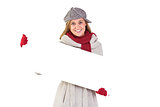 Happy blonde in winter clothes showing card