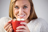 Pretty blonde enjoying hot chocolate on the couch