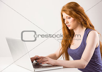 Pretty redhead working on laptop