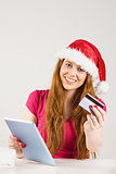 Festive redhead shopping online with tablet