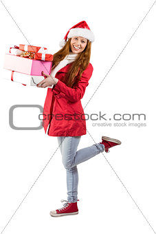 Festive redhead holding pile of gifts