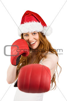 Festive redhead punching with boxing gloves