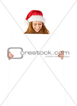 Festive redhead smiling at camera holding poster