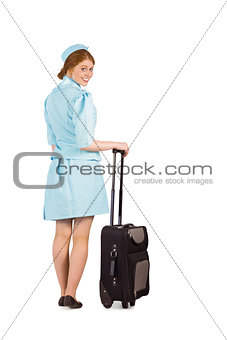 Pretty air hostess leaning on suitcase