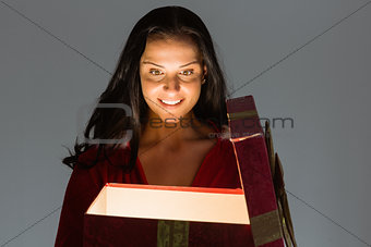 Smiling woman opening christmas present