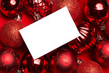 White page on red christmas baubles