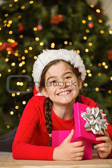 Little girl opening a gift at christmas